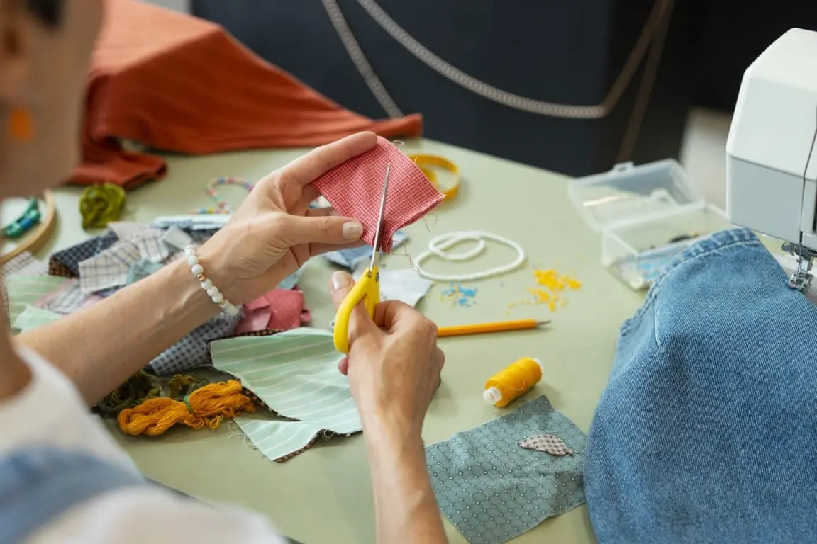 high angle woman repairing fashion goods